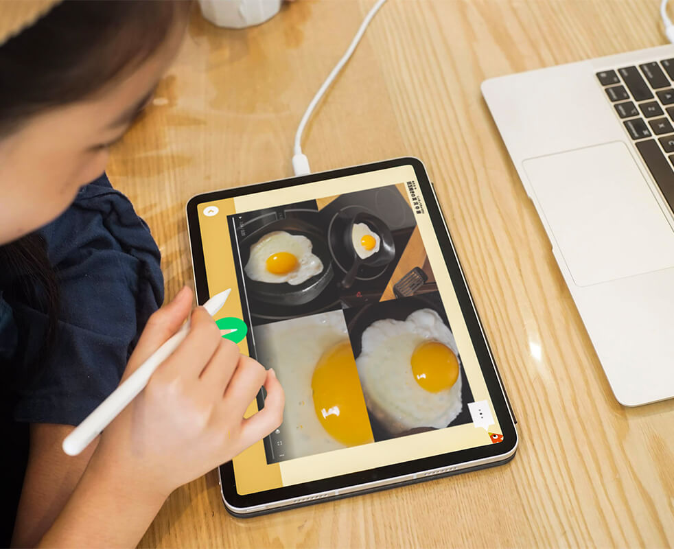 画像：こどもがiPad上の4枚の画像にペンで文字を書こうとしている様子