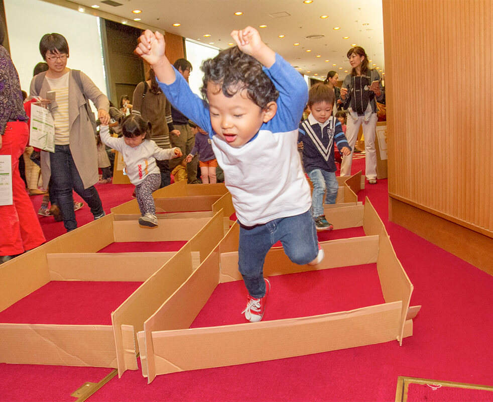 画像：段ボールで四角に囲われたエリアを飛び跳ねる男の子の様子