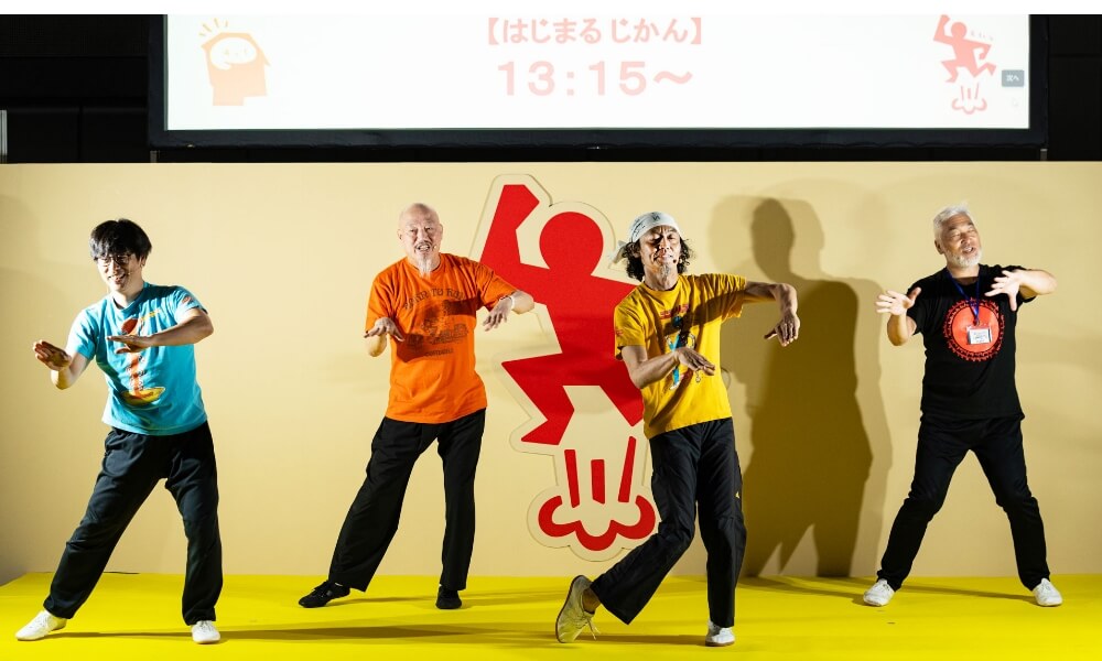ステージ上で4人の男性がダンスパフォーマンスをしている様子。