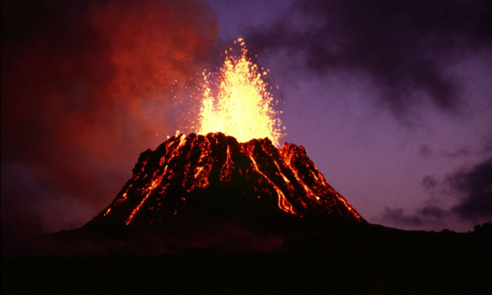 火山が噴火し、溶岩が山肌を流れ落ちている迫力ある写真。