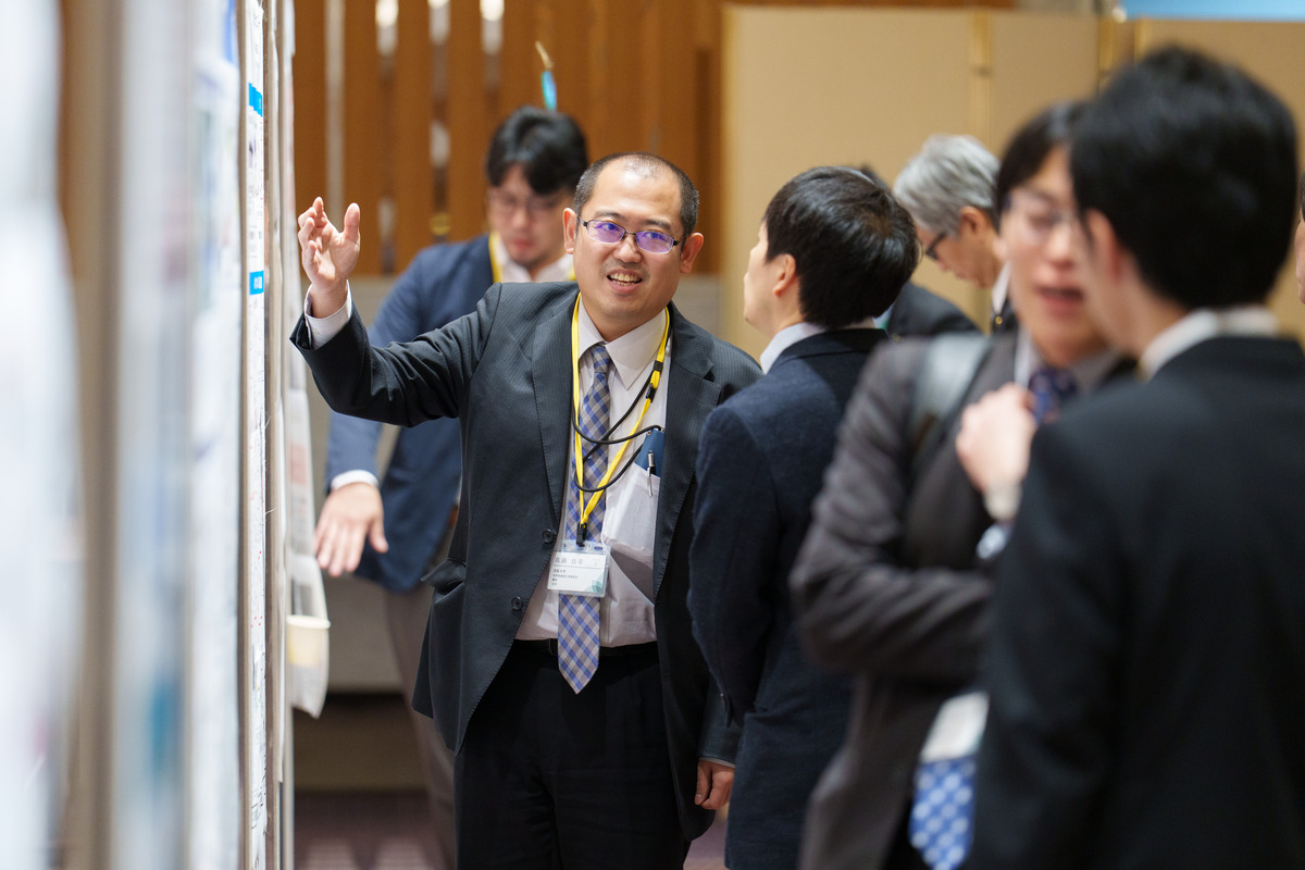 写真：ポスターを前に議論する研究者