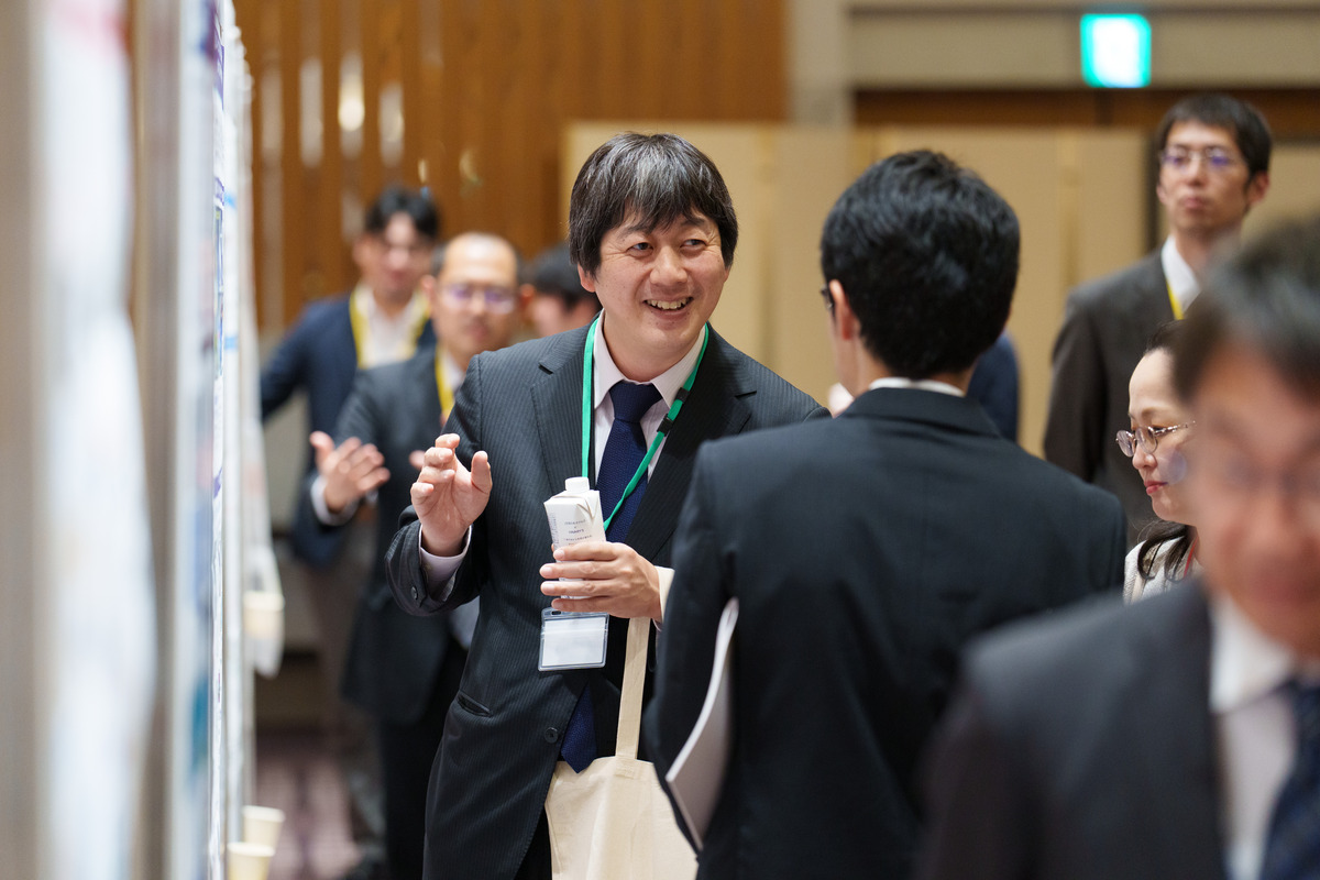 写真：ポスターを前に議論する研究者