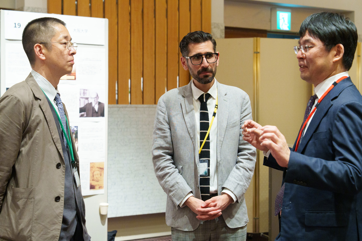 写真：ポスターを前に議論する研究者