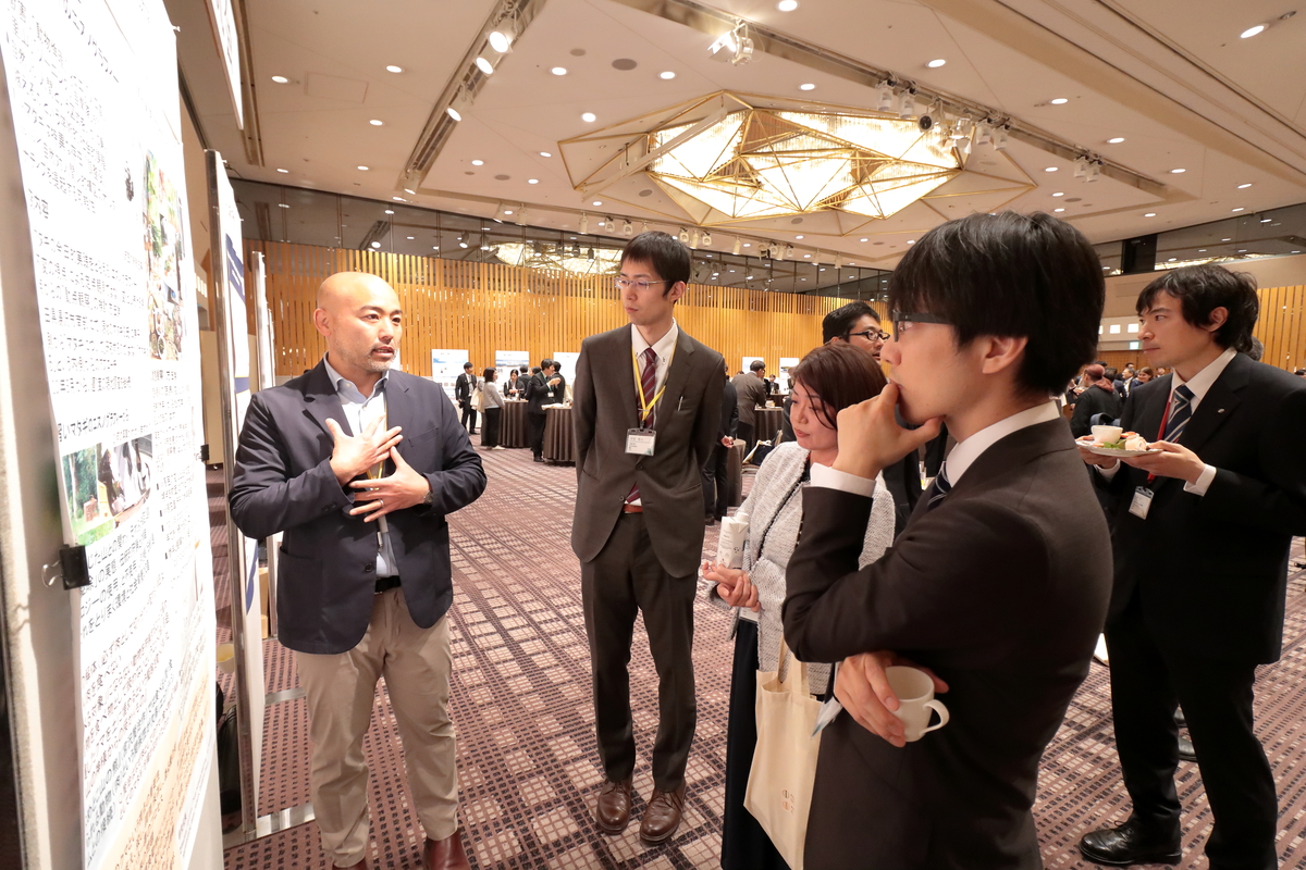 写真：懇親会中もポスターの前で説明を続ける参加者