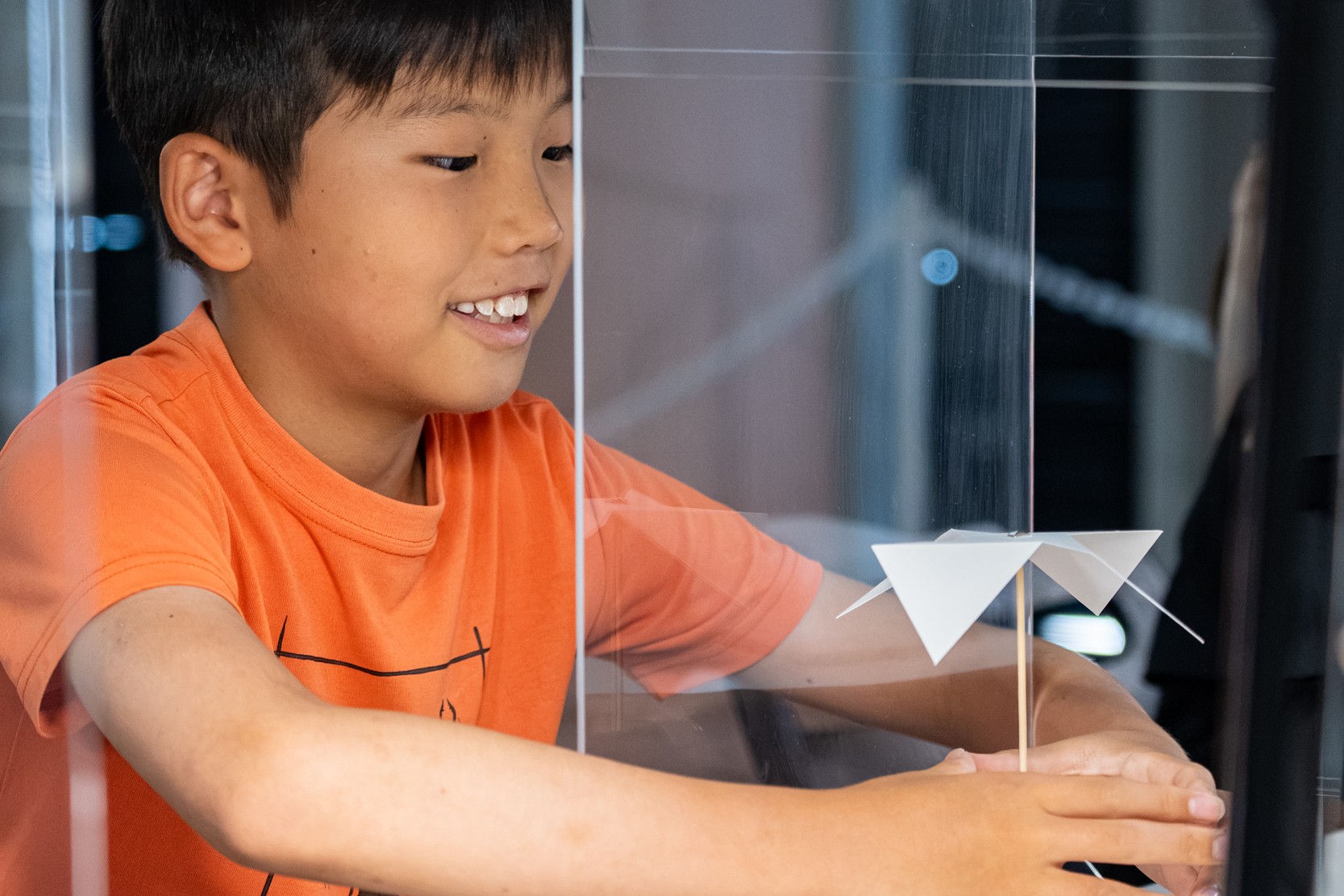 手のひらをかざして風車を回している子どもの様子