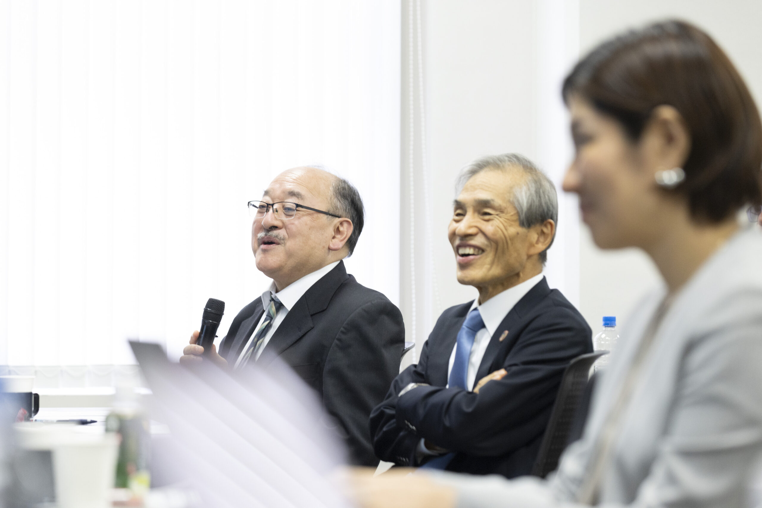 写真：発表に対して質問をする森運営委員と、耳を傾ける西尾運営委員、星野氏
